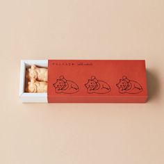 an orange box filled with three different types of cookies in it's opening and sitting next to each other