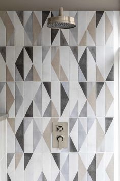 a bathroom with a tiled wall and shower head