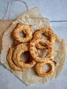 fried onion rings sitting on top of a piece of wax paper