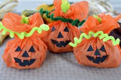 three orange bags filled with candy sitting on top of a table