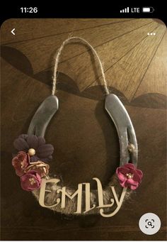 a necklace with flowers and the word lilly hanging from it's side on a table