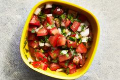 a yellow bowl filled with tomatoes and onions