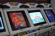 four video game machines lined up next to each other in front of a tv screen