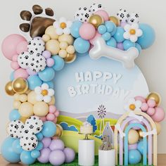 a dog themed birthday party with balloons and decorations on the table, including a large balloon arch