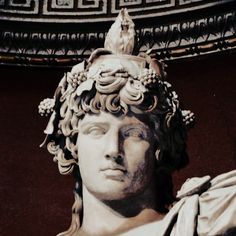 a statue of a man with a bird on top of his head in front of a wall