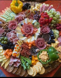 a platter filled with lots of different types of meats, cheeses and crackers