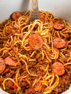 a large bowl filled with spaghetti and sausage