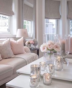 a living room filled with lots of furniture and flowers on top of a coffee table