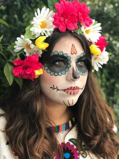 a woman with face paint and flowers in her hair