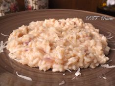 a brown plate topped with rice on top of a wooden table next to a bottle