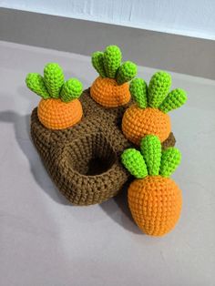 crocheted carrots and cauliflower on top of a piece of wood