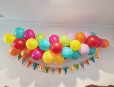 a bunch of balloons hanging from the ceiling