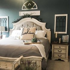 a bedroom with a bed, nightstands and mirror on the wall in front of it