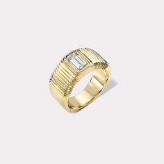 a gold ring with a baguette cut diamond in the center, on a white background