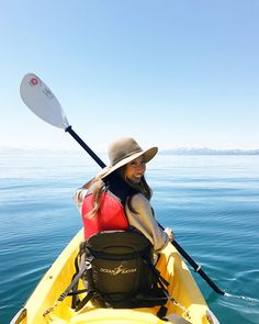 a woman wearing a hat is in a kayak