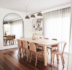 a dining room table and chairs in front of a mirror