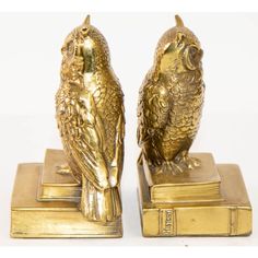 two gold colored owls sitting on top of each other's bookends in front of a white background