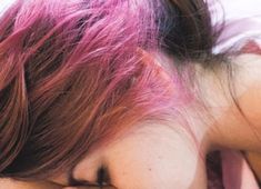 a woman with pink hair has her eyes closed