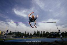 a man is jumping high in the air on a trampoline with his feet up