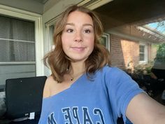 a woman is taking a selfie in front of her house and smiling at the camera