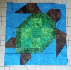 a piece of quilted material with a green turtle on it's back and side