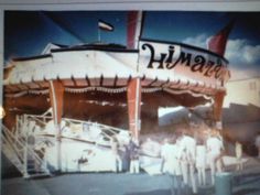 an old photo of people standing in front of a carnival