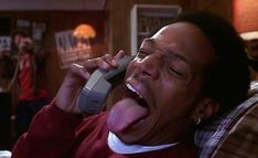 a man with his tongue hanging out while talking on the phone