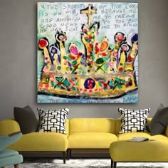 a living room with yellow couches and a painting on the wall above it's head