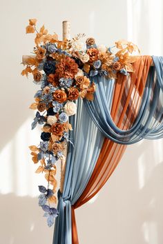 an arrangement of flowers is hanging on the curtain