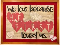 we love because he first loves us sign with hearts on it and the words,'we love because he first loves us '