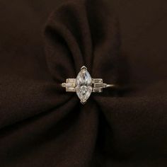 Engagement Ring: ✦ Main Stone Details ✧ Shape: Marquise Cut Moissanite ✧ Weight: 0.90 CT Approx ✧ Diamond Size: 10x5mm ✧ Color: White ✧ Clarity: VVS2 ✦ Side Stone Details ✧ Shape: Baguette Cut Moissanite ✧ Weight: 0.20 CT Approx ✧ Color: White ✧ Clarity: VVS2 ✦ While we do our best to showcase the true color of the stone, Moissanite are unique and vary in appearance. Colors may vary slightly due to your lighting and monitor display settings. ✦ Also Available in Aquamarine, Morganite, Blue Topaz, Timeless Marquise White Diamond Ring, Timeless White Marquise Diamond Ring, Timeless White Diamond Ring Marquise Cut, White Timeless Marquise Cut Diamond Ring, Three Stone Marquise Cut Diamond Ring Gift, Modern Marquise Cut Cubic Zirconia Wedding Ring, White Marquise Cut Promise Diamond Ring, Timeless White Marquise Cut Cluster Ring, Silver Marquise Three-stone Ring