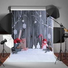 a christmas scene with snow, candy canes and decorations on a wooden fence backdrop