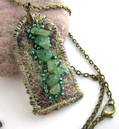 a necklace with green beads and wire wrapped around it