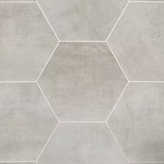 a tile wall with hexagonal tiles in grey and white colors on the floor