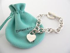 Offered for sale is a wonderful and rare Tiffany and Co. Sterling Silver "Mom" Heart Padlock bracelet.  The piece is made from substantial and bright Tiffany silver, and yet retains a very feminine feel to it.  Attached to its very substantial Tiffany & Co Silver Toggle charm bracelet is a Heart padlock charm with "Mom" written in beautiful script.  The"Mom" padlock charm opens and closes and thus can be used as a charm on a necklace or as part of another charm bracelet! Super versatile Tiffany And Co Jewelry Valentines Day, Tiffany Charm Bracelet, Tiffany And Co Bracelet, Heart Padlocks, Toggle Bracelet, Christmas Charms, Jewelry Lookbook, Silver Charm Bracelet, Tiffany And Co