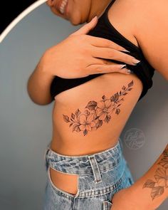 a woman with a flower tattoo on her stomach