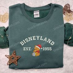 Disneyland Pooh Santa Hat Embroidered Sweatshirt, Disney Christmas Embroidered Sweatshirt, Best Christmas Gift Ideas Step into the enchanting world of Tinicloset, where we create fashion that’s as sweet as honey and as adorable as Winnie the Pooh himself. Our Disneyland Pooh Santa Hat embroidered sweatshirt collection is a whimsical celebration of the festive season, seamlessly blending Disney magic with holiday cheer. Each piece is a work of art, designed to make you feel like you’v Disney Crew Neck Sweatshirt With Embroidered Logo, Disney Sweatshirt For Winter Fan Events, Disney Embroidered Long Sleeve Sweatshirt, Disney Cotton Sweatshirt For Winter, Winter Disney Cotton Sweatshirt, Sweatshirt Collection, Embroidered Sweatshirt, Christmas Gift Ideas, Disney Christmas