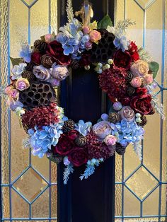 a blue door with a wreath on the front and side of it that is decorated with flowers