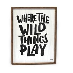 a sign that says where the wild things play in black and white lettering on a wooden frame