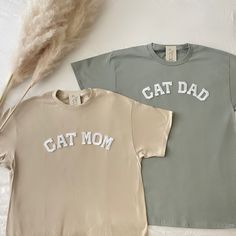 two t - shirts with the words cat mom and cat dad written in white on them