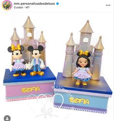 two disney figurines sitting on top of each other in front of a castle