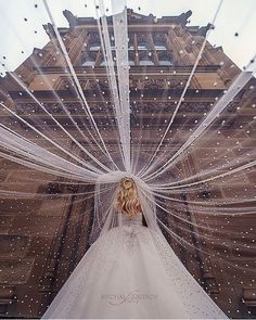 a woman in a white wedding dress is standing outside