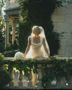 a woman in a wedding dress sitting on a bench