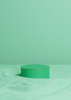 a green round object sitting on top of a white surface with wavy lines in the background