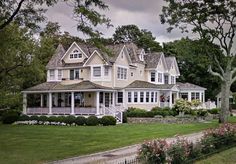 a large white house sitting on top of a lush green field