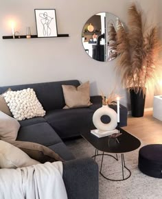 a living room filled with furniture and a large mirror on the wall above it's coffee table