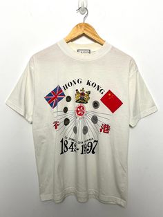 This tee shirt shows slight discoloration around the collar and has a small mark on the lower front side. (please see photos for flaws) Measurements pit to pit: 20 inches  Top to bottom: 25 inches Vintage Hong Kong, China Flag, Graphic Tee Shirt, Graphic Tee Shirts, Vintage Tees, Cool Shirts, Hong Kong, Tee Shirt, Graphic Tee