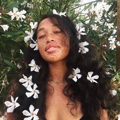 a woman with freckled skin and flowers in her hair