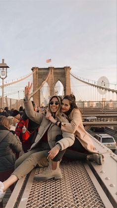 two women taking a selfie in front of the brooklyn bridge