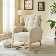 a white rocking chair sitting in a living room next to a window